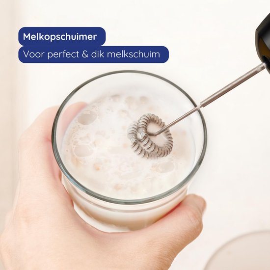 Hand houdt een zilverkleurige staafmixer met opschuimaccessoire in een glas melk. "Melkopschuimer. Voor perfect & dik melkschuim."