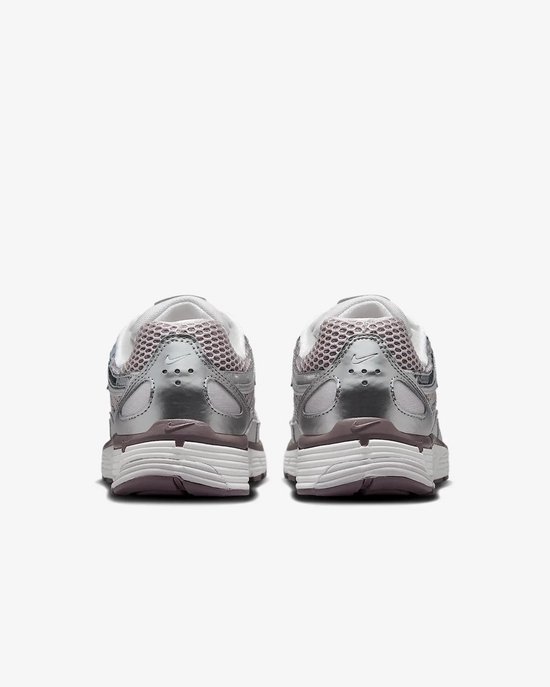Achterkant van zilverkleurige Nike P-6000 sneakers met paarse hakdetails.