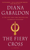 Boek kaft van "The Fiery Cross" door Diana Gabaldon, met een gouden Keltische broche.