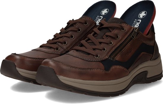 Paar bruine leren Rieker sneakers met rits en veters. Beige zolen en donkerblauwe accenten.