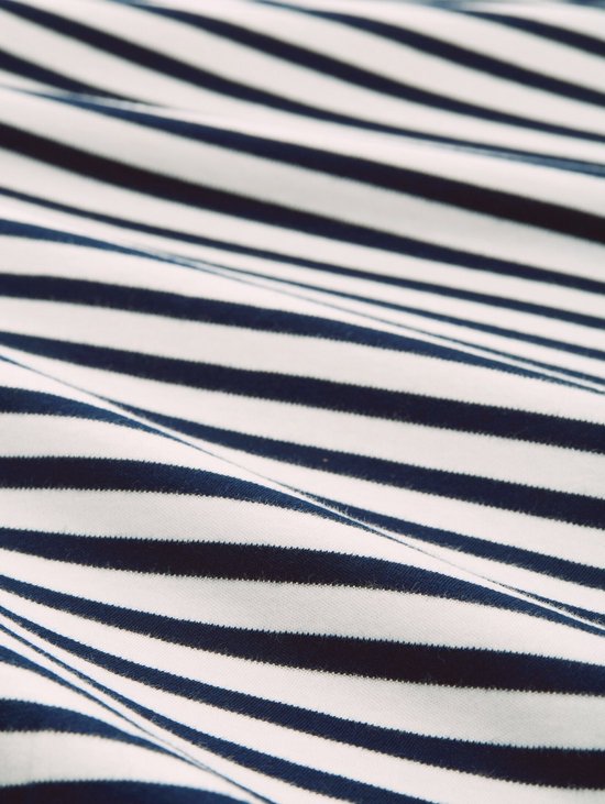 Detailopname van een wit T-shirt met donkerblauwe strepen.