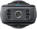 Zwarte Insta360 camera met geribbelde zijkanten, een grote lens en een blauw indicatielampje, op een zwarte achtergrond.