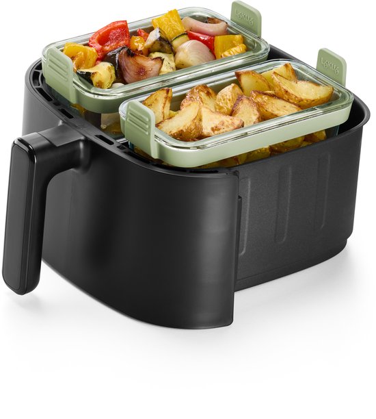 Zwarte airfryer met twee gestapelde lichtgroene glazen schalen. De bovenste schaal bevat geroosterde groenten, de onderste schaal aardappelpartjes.