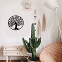 Décoration d'arbre de vie en métal noir avec branches et feuilles détaillées dans un cercle, suspendue à un mur blanc au-dessus d'un buffet.