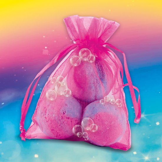 Drie roze en paarse badbruisballen in een doorzichtig roze netzakje met bubbels op een kleurrijke achtergrond.