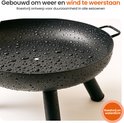 Zwarte, metalen vuurschaal bedekt met regendruppels. 'Roestvrij en waterdicht'.