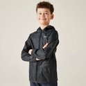 Jongen met gekruiste armen in zwarte regenjas.