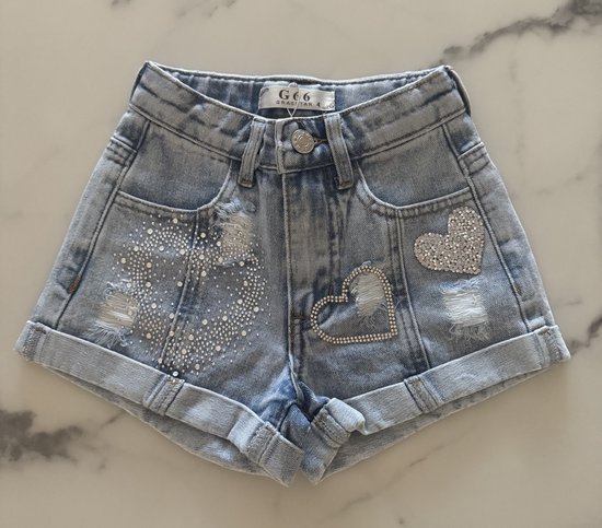 Lichtblauwe denim shorts met distressed details, glitterhart op de zak en een hartvormige glitterapplicatie.