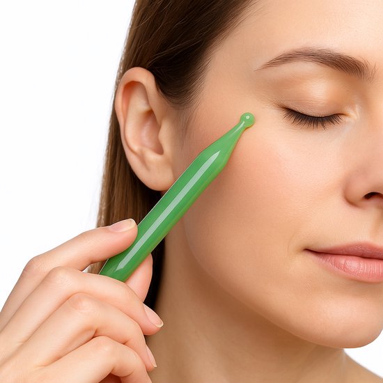 Vrouw gebruikt groene massagepen bij haar oog.