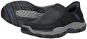Zwarte Skechers slip-on schoen, zijaanzicht, met grijze zool en de zool van de andere schoen zichtbaar.
