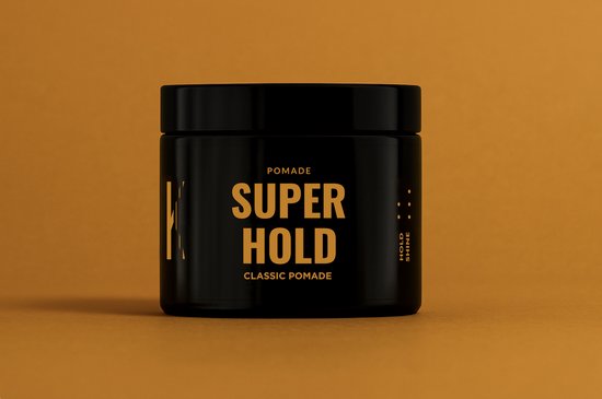 Zwarte pot pomade 'SUPER HOLD CLASSIC POMADE' op een oranje achtergrond.