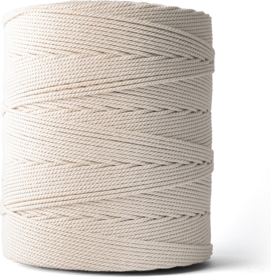 Une bobine de cordelette macramé écru sur fond blanc.