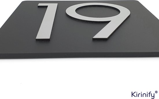 Zwart huisnummerbord 12x12cm met zilverkleurige cijfers '19', van de zijkant gefotografeerd.