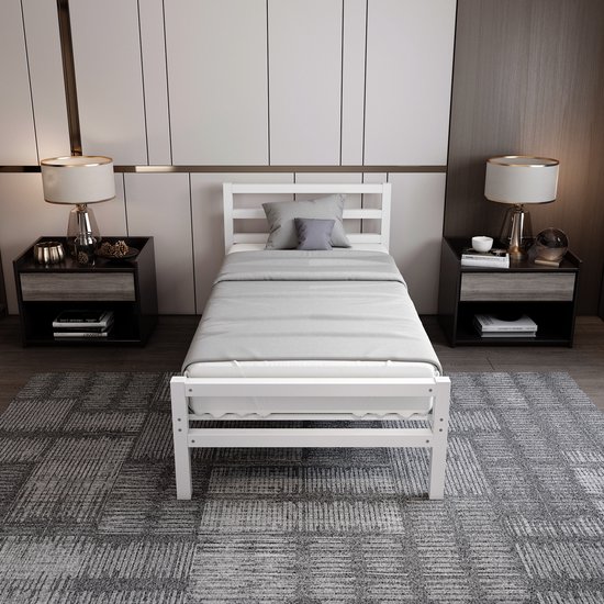 Wit metalen eenpersoonsbed met opgemaakte matras en kussens, centraal geplaatst in een moderne slaapkamer met nachtkastjes en lampen.