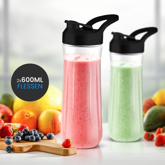 Twee 600ML flessen gevuld met smoothies, roze en groen, naast een assortiment vers fruit. Tekst: '2x 600ML FLESSEN'.