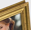 Close-up van een vrouw met opgestoken haar, oogmake-up en oorbellen, naast een gouden fotolijst.