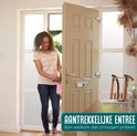 Een vrouw met krullend haar, in een gestreepte top en spijkerbroek, stapt een huis binnen.