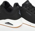 Zwarte Skechers Uno dames sneakers met witte zolen en een zichtbare luchtkamer.