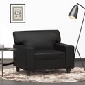 Zwarte fauteuil met armleuningen, op een zachte ronde mat, naast een bijzettafel.