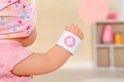 Baby pop met pleister op de arm met roze bloem erop.