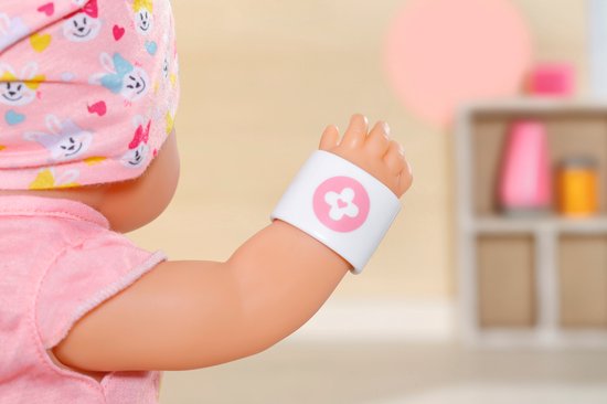 Baby pop met pleister op de arm met roze bloem erop.