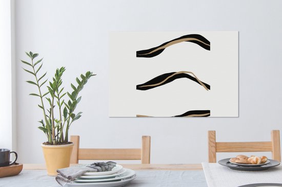 Abstract schilderij met drie zwarte en goudkleurige lijnen boven een eettafel met servies.