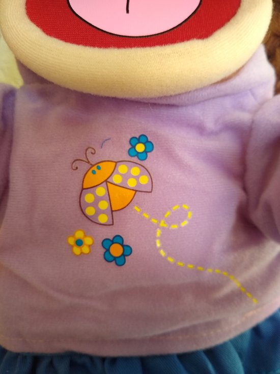 Detail van paars shirt met lieveheersbeestje en bloemenprint van poppenkastpop Amy.