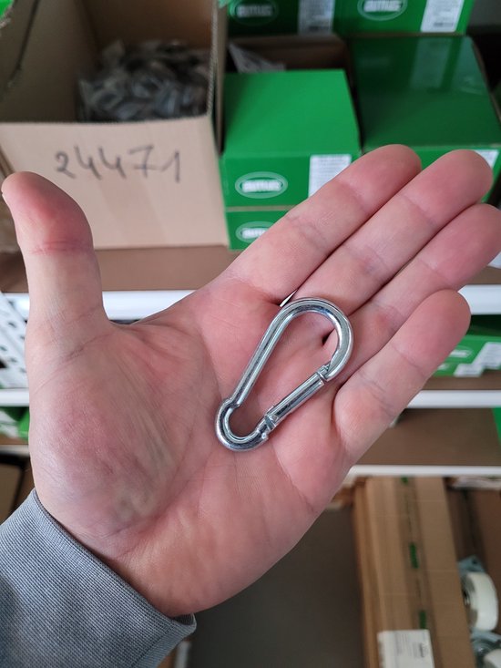 Een hand die een zilverkleurig karabijnhaakje met veersluiting vasthoudt.