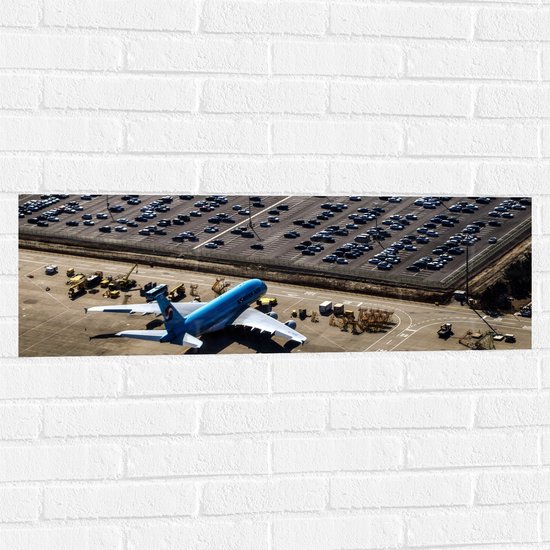 WallClassics - Muursticker - Blauw Vliegtuig op Vliegbasis - 90x30 cm Foto op Muursticker