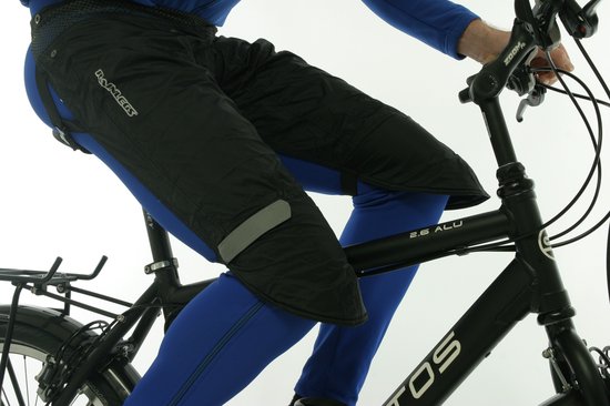 Zwarte Rainlegs gedragen door een fietser met blauwe fietsbroek.