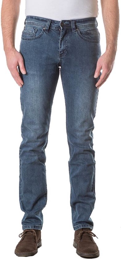 Model van voren gezien in een blauwe spijkerbroek met slanke pasvorm en licht stonewashed effect.