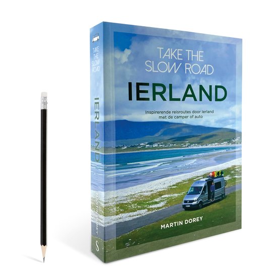 Boekomslag en potlood: 'Take the slow road Ierland'. Boekomslag toont een camper aan zee, met een potlood ernaast.