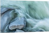WallClassics - PVC Schuimplaat- Blauw Stromend Water langs Stenen - 120x80 cm Foto op PVC Schuimplaat