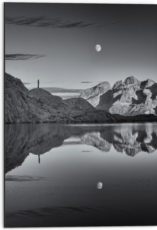 WallClassics - Dibond - Persoon op Rotsen langs Water met Maan in zwart-wit - 50x75 cm Foto op Aluminium (Met Ophangsysteem)