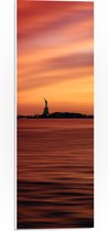 WallClassics - PVC Schuimplaat - Oranje Lucht boven Vrijheidsbeeld in New York - 20x60 cm Foto op PVC Schuimplaat (Met Ophangsysteem)