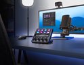 Stream Deck+ op een bureau in een studio-opstelling met computers, microfoon en verlichting.