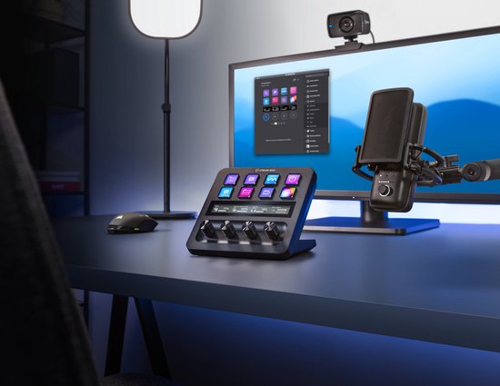 Stream Deck+ op een bureau in een studio-opstelling met computers, microfoon en verlichting.