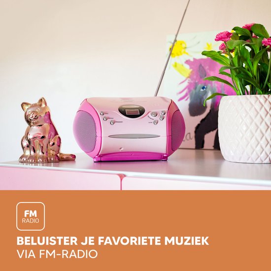 Roze Lenco radio CD-speler op een bureau met decoraties.