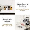 Vier transparante voorraadpotten met ontbijtgranen, suiker, koffie en pasta op een keukenblad. Beschrijving: Organiseer je keuken.