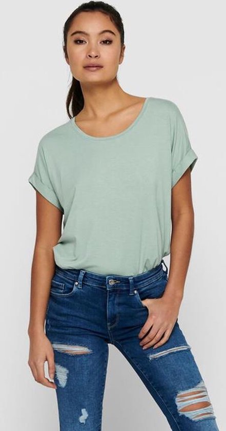 Lichtgroen dames T-shirt met korte omgeslagen mouwen en boothals, gedragen op een blauwe ripped jeans.
