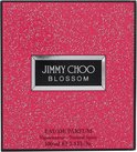Roze glinsterende doos van Jimmy Choo Blossom Eau de Parfum met zwarte merknaam.