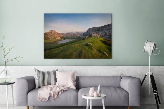 Canvas schilderij 180x120 cm - Wanddecoratie Berghut kijkt uit op meer bij Nationaal park Picos de Europa in Spanje - Muurdecoratie woonkamer - Slaapkamer decoratie - Kamer accessoires - Schilderijen