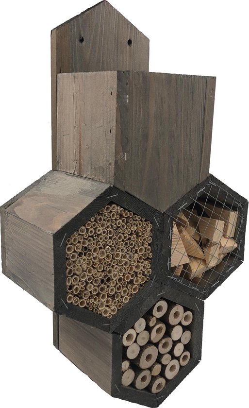 Houten bijenhotel met donkergrijze hexagonale secties gevuld met bamboe, houtblokken en stammetjes.