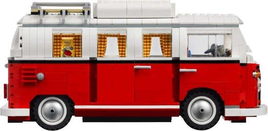 Zijaanzicht van een rode LEGO camperbus met witte dakopbouw, getinte ramen en geblokte gordijnen.