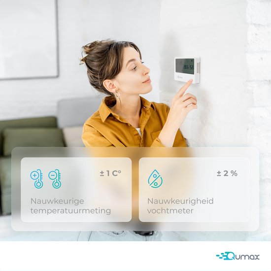 Vrouw gebruikt Qumax thermometer aan de muur. Nauwkeurige temperatuur- en vochtigheidsmeting.