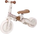 Crèmekleurige loopfiets met bruine zitting en handvatten. Het frame is versierd met een bloemenprint.