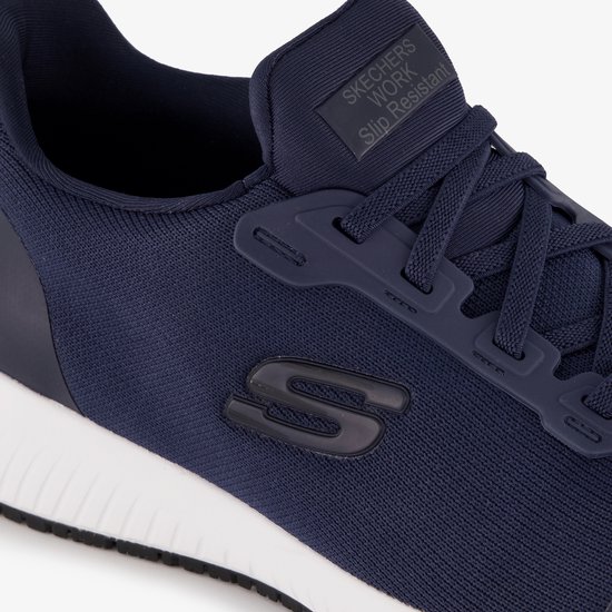 Close-up van de donkerblauwe instapper, met veters, zijlogo S en "SKECHERS WORK Slip Resistant" opschrift op de tong.
