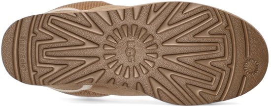 Onderkant van beige UGG sneakers met een gegroefde zool en UGG-logo.