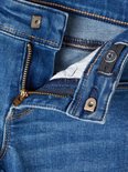 Detail van de tailleband van de jeans met rits en knoop.