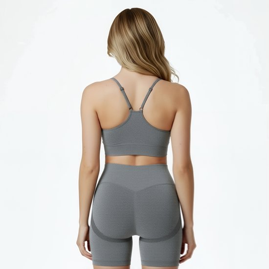 Achterkant van een model met blonde haren, draagt een grijze sport BH en een grijze short.